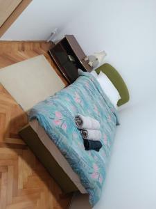 Una cama con un par de zapatos encima. en Apartman 019 en Zaječar