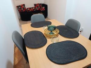 une table en bois avec des chaises et un vase. dans l'établissement Apartman 019, à Zaječar