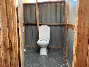 a bathroom with a toilet in a wooden stall at Kambu Mara Camp in Sekenani