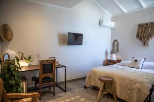 a bedroom with a bed and a desk and a tv at Primi Seacastle in Cape Town