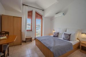a bedroom with a bed and a desk and a window at Dubravko in Metajna +66 photos