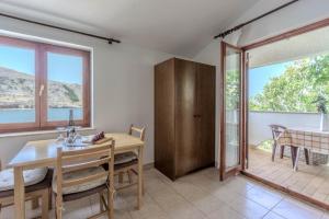 a dining room with a table and a glass door at Dubravko in Metajna