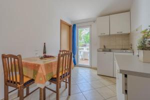 a kitchen with a table and chairs and a kitchen with a window at Dubravko in Metajna