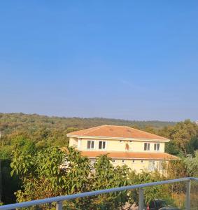 a house on a hill with trees in front of it at Budget Hotel Tourist Inn in Arnavutköy