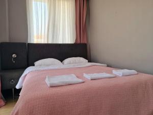 a bedroom with a bed with two towels on it at Budget Hotel Tourist Inn in Arnavutköy