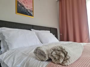 a white bed with a blanket on top of it at Budget Hotel Tourist Inn in Arnavutköy