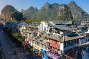 a view of a street with mountains in the background at Yangshuo EMOJI YOUTH HOSTEL in Yangshuo
