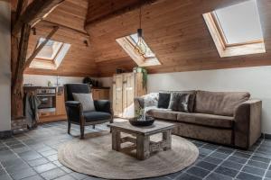 a living room with a couch and a table at Boerensuite, heerlijk verblijf in het Karschop in Riel
