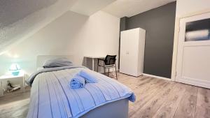 - une chambre avec un lit et des serviettes bleues dans l'établissement Work&Stay in Neumünster, à Neumünster