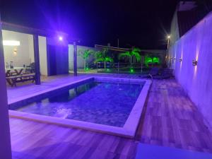 a swimming pool at night with purple lights at Casa Barra de são Miguel in Barra de São Miguel