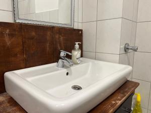 La salle de bains est pourvue d'un lavabo blanc et d'un miroir. dans l'établissement Work&Stay in Neumünster, à Neumünster