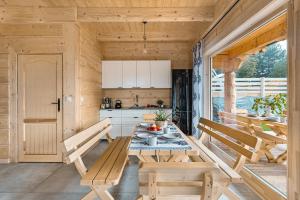 a kitchen with a wooden table and benches in a room at Pienińska Przystań in Czorsztyn