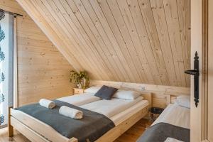 1 dormitorio con 2 camas en un techo de madera en Pienińska Przystań, en Czorsztyn