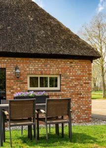 a table and chairs in front of a brick building at Boerensuite, heerlijk verblijf in het Karschop in Riel