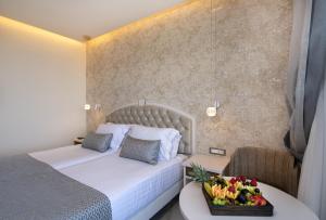 a hotel room with a bed and a tray of fruit on a table at Vantaris Luxury Beach Resort in Georgioupolis