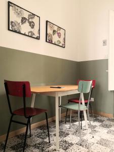 a table and chairs in a room with green walls at Central Apartment with Panoramic Terrace in Catania