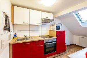 a red kitchen with a sink and a stove at Tapas Restaurante 2 in Viersen
