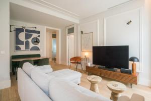 a living room with a white couch and a flat screen tv at Luxury condo in heart of Baixa-Chiado in Lisbon