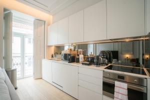 a kitchen with white cabinets and a stove at Luxury condo in heart of Baixa-Chiado in Lisbon