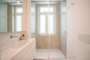 un bagno con doccia in vetro e lavandino di Luxury condo in heart of Baixa-Chiado a Lisbona Altre 37 foto