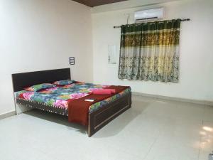 a bedroom with a bed in a room with a window at Siddhivinayak Resort NX in Malvan