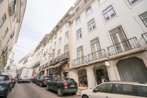 una strada con auto parcheggiate sul lato di un edificio di Luxury condo in heart of Baixa-Chiado a Lisbona
