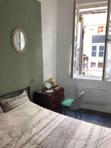 een slaapkamer met een bed, een stoel en een raam bij Appartement 30m² RDC 2 pièces in Joigny