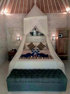 a bedroom with a large bed with a canopy at The Lucky Cottage in Nusa Lembongan