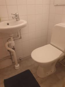 a bathroom with a white toilet and a sink at Mycket Centralt Hel studio lägenhet in Umeå