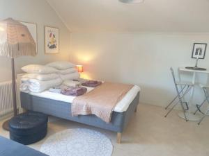 a bedroom with a bed with a pile of pillows at Mycket Centralt Hel studio lägenhet in Umeå