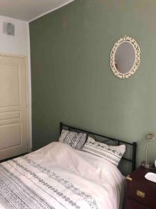 een slaapkamer met een bed met een spiegel aan de muur bij Appartement 30m² RDC 2 pièces in Joigny