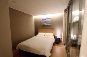 Una cama o camas en una habitación de Haeundae Bona Travel