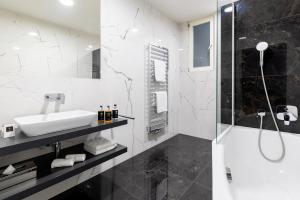 a black and white bathroom with a sink and a shower at Hotel Ikona in Prague