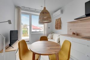 a kitchen and dining room with a table and chairs at Przypływ by Grand Apartments in Gdynia +21 photos