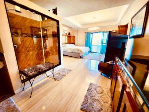 a room with a large shower and a bedroom at Paradise Cove Villa 2BR Oceanfront Haven, Private Infinity Pool & Jacuzzi, King Bed, 2 Full Beds, 2 Extra Dutton Beds, WiFi, Private Parking in Sigayan