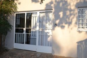 une porte blanche d'une maison avec une fenêtre dans l'établissement Bryanston Elgin - Cottage 1, à Johannesbourg