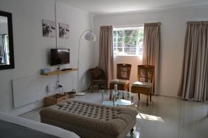 un salon avec un canapé et une table dans l'établissement Bryanston Elgin - Cottage 1, à Johannesbourg 2 autres photos