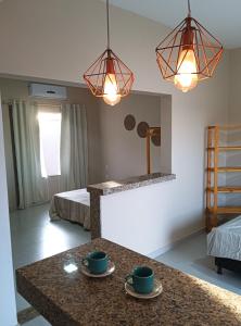 a room with two cups on a counter and two beds at Casa - Luxo e Conforto, Hidromassagem a 50m do Mar in São Mateus