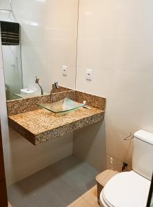 ein Bad mit einem Waschbecken und einem WC in der Unterkunft Casa - Luxo e Conforto, Hidromassagem a 50m do Mar in São Mateus