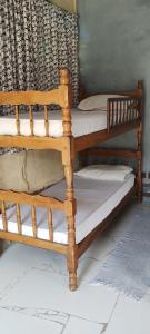 2 Etagenbetten aus Holz in einem Zimmer in der Unterkunft Hostel Recanto Caiçara in São Sebastião