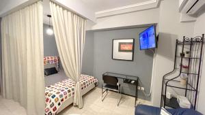 Cette petite chambre comprend deux lits et une télévision. dans l'établissement Studio THEA Thessaloniki, à Thessalonique