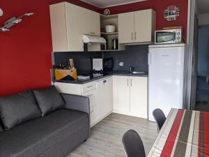 a living room with a couch and a kitchen at Bol d'air pur au coeur du pays basque in Souraïde