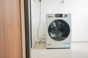 naast een deur staat een wasmachine bij Ipoh Tambun Sunway Onsen Suite 3R2B Maya in Tambun