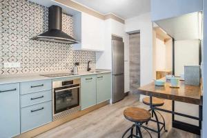 een keuken met een tafel en een fornuis bovenste oven bij Apartamento Arresi Deluxe in Bermeo