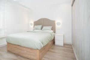 een slaapkamer met een groot bed met een houten hoofdeinde bij Apartamento Arresi Deluxe in Bermeo
