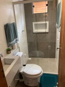 a bathroom with a toilet and a glass shower at Pousada Chalé Flor de Hibisco 3 in Penha +24 photos