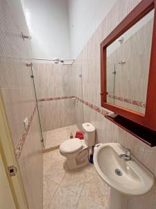 uma casa de banho com um WC, um lavatório e um espelho. em Hostal El fin del afán em Jericó