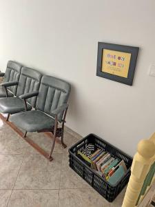 a waiting room with two chairs and a basket of books at Hostal El fin del afán in Jericó