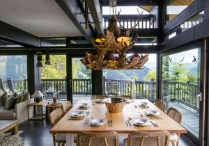 Lauchernalp Resort Residences في Wiler: غرفة طعام مع طاولة وثريا