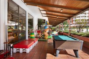 une terrasse avec un billard et une aire de jeux dans l'établissement Apartamento da Rocha I, à Portimão
